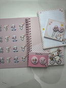 Kit papelaria Caderno Ovelhinha com 100 folhas de 90 gramas, ,2 blocos de anotações, 02 bottons personalizados e 02 clips